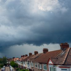 Storm clouds over a London street of houses and parked cars