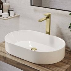 A large, ceramic sink with gold hardware from Better Bathrooms.
