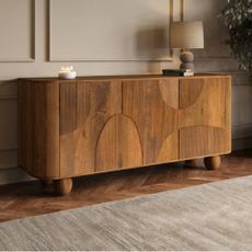 A solid wood, detailed sideboard from Furniture123 in a modern, panelled living room. 