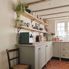 Corner of kitchen with Shaker cabinetry, coffee machine and open shelving